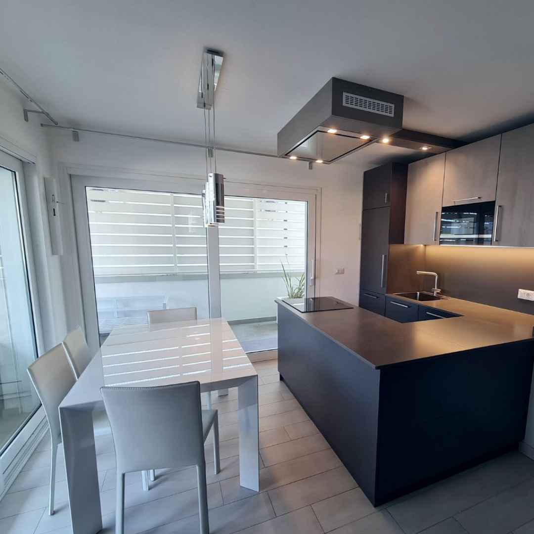 Cucina moderna con penisola e ante con maniglie sottili in acciaio