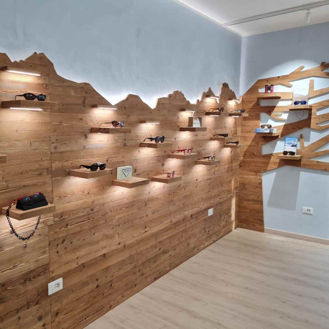 Parete attrezzata in legno con il profilo delle montagne per l'esposizione di occhiali