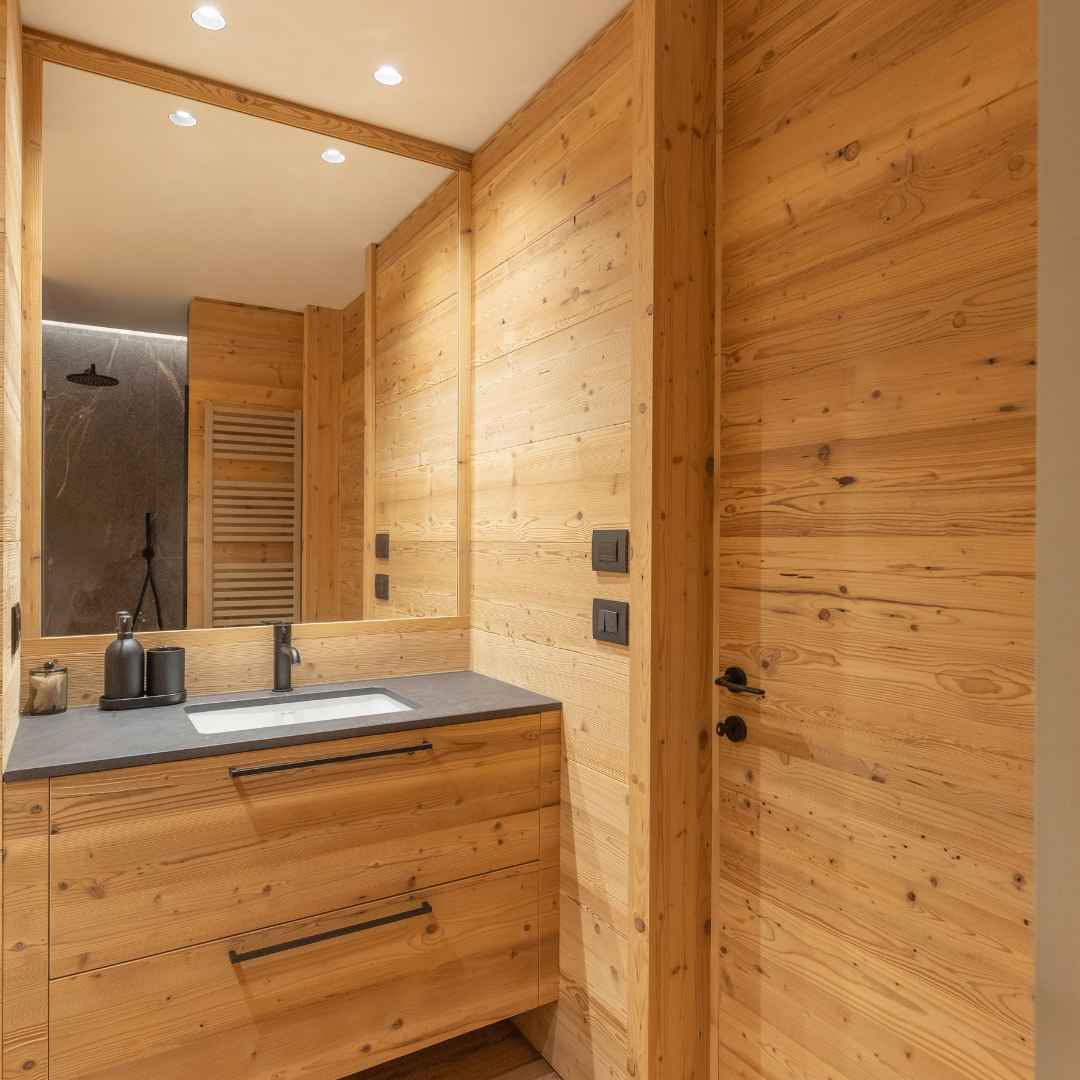 Bagno interamente rivestito in legno con porta complanare