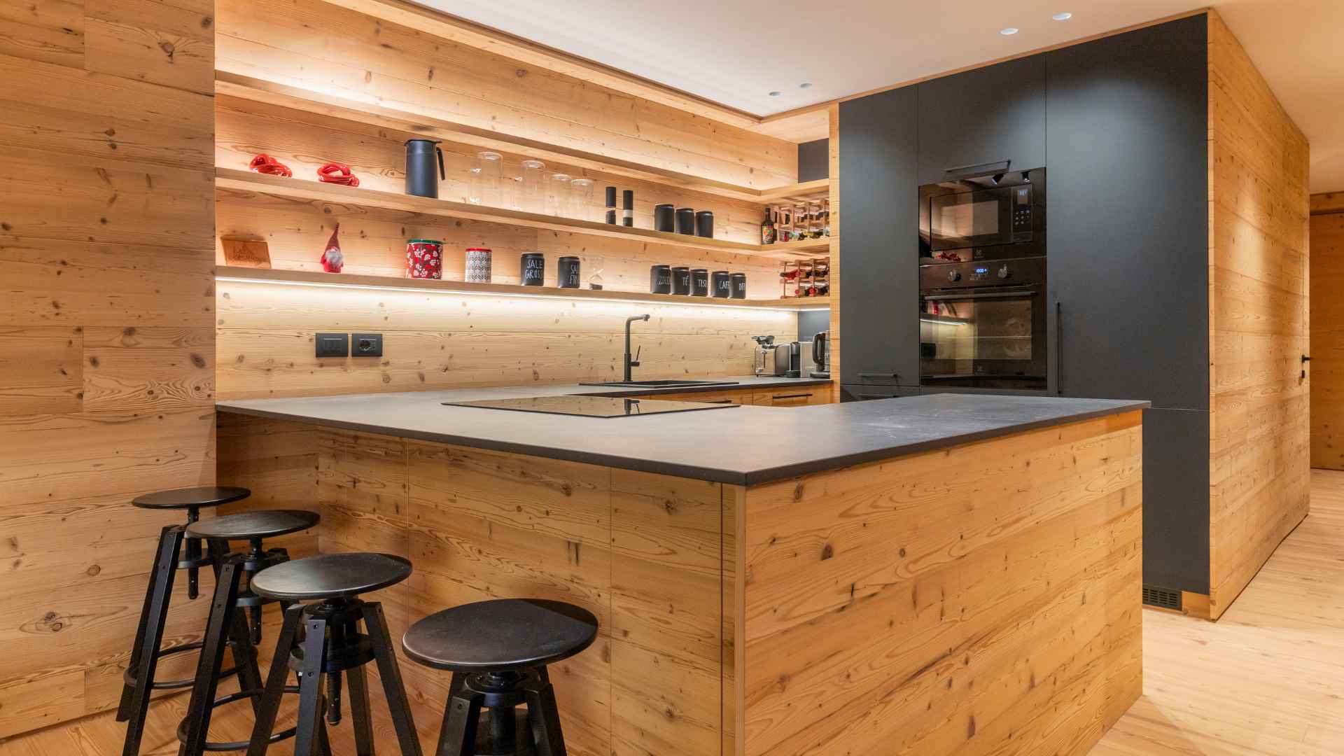 Cucina in legno di montagna stile moderno con piano cucina nero