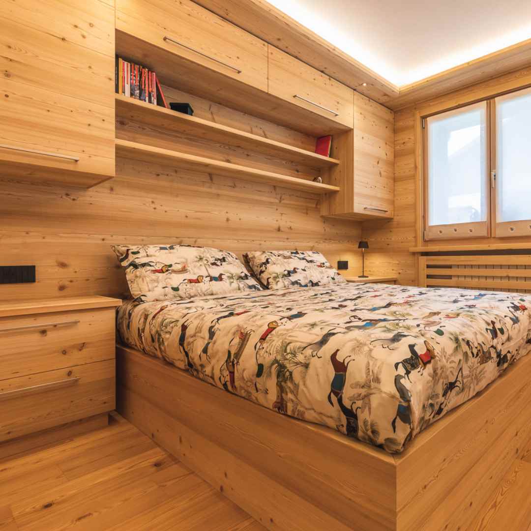 Camera matrimoniale moderna con legno liscio e mobili salvaspazio