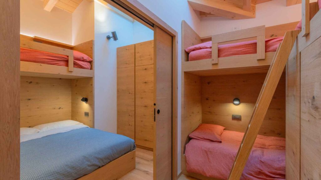 Camerette di montagna con letti a castello in legno con armadi