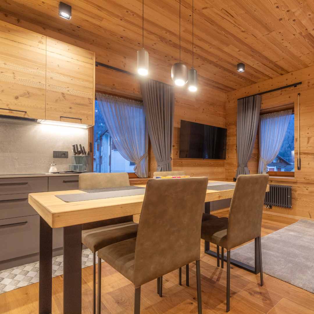 Zona prano con tavolo in legno e sedie imbottite grigie