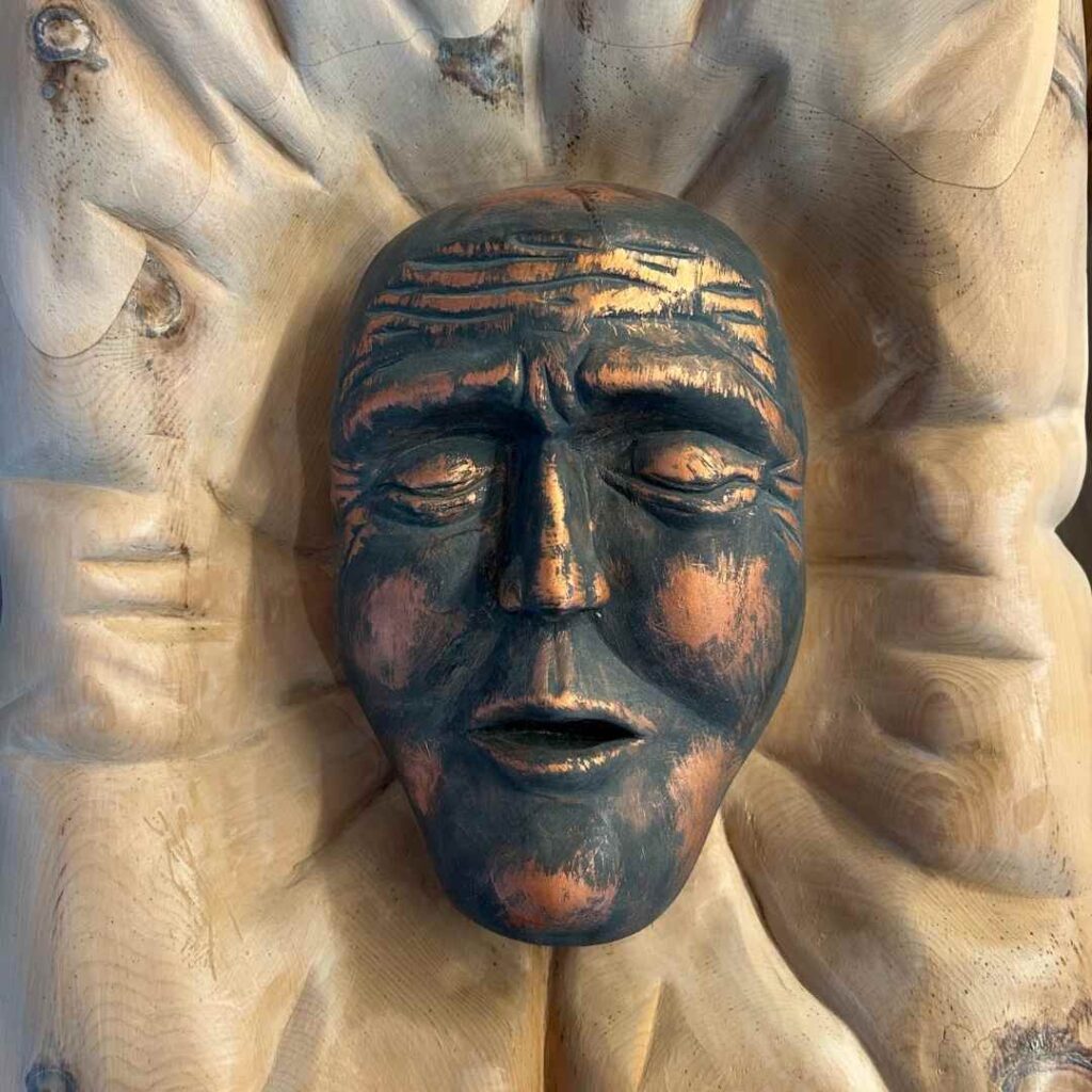 Scultura in legno che raffigura un volto dormiente