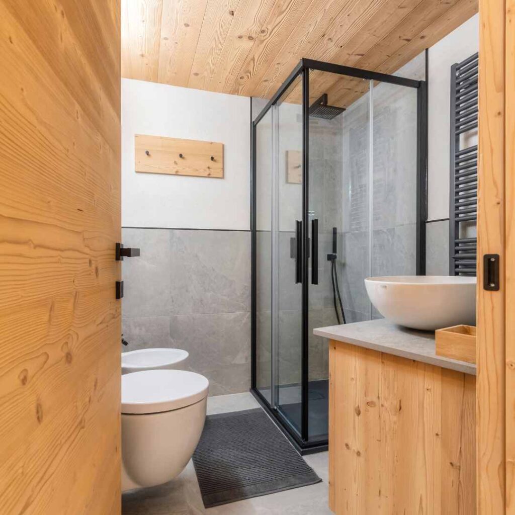 Bagno moderno di una casa di montagna con doccia dai profili di metallo nero