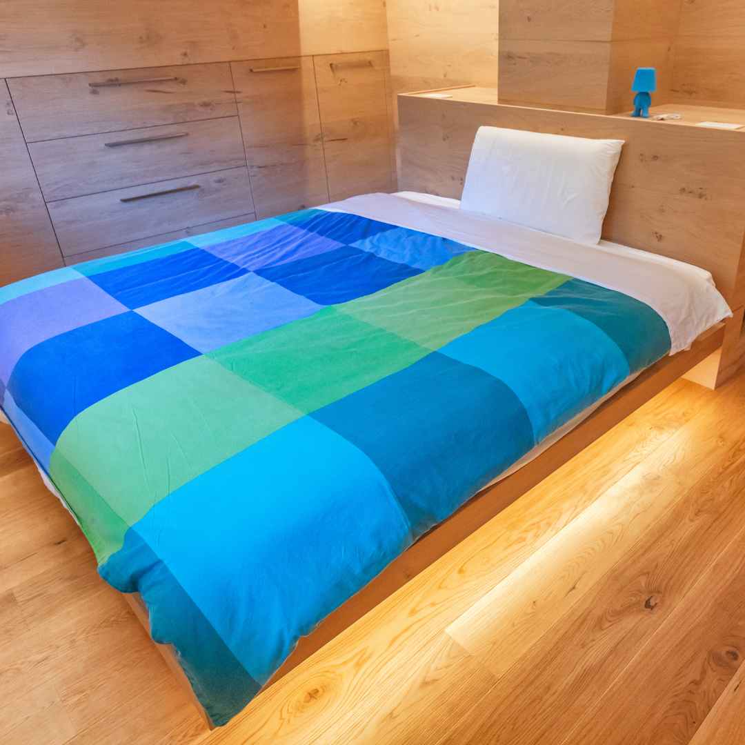 Camera da letto rivestita in legno di rovere con cassettiera e letto in legno