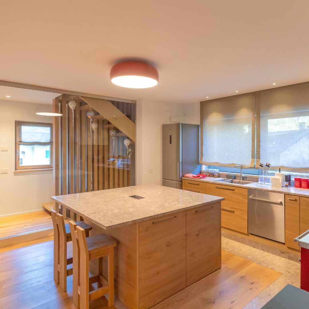 Cucina moderna con maniglie in acciaio e isola centrale con piano in pietra Dolomia