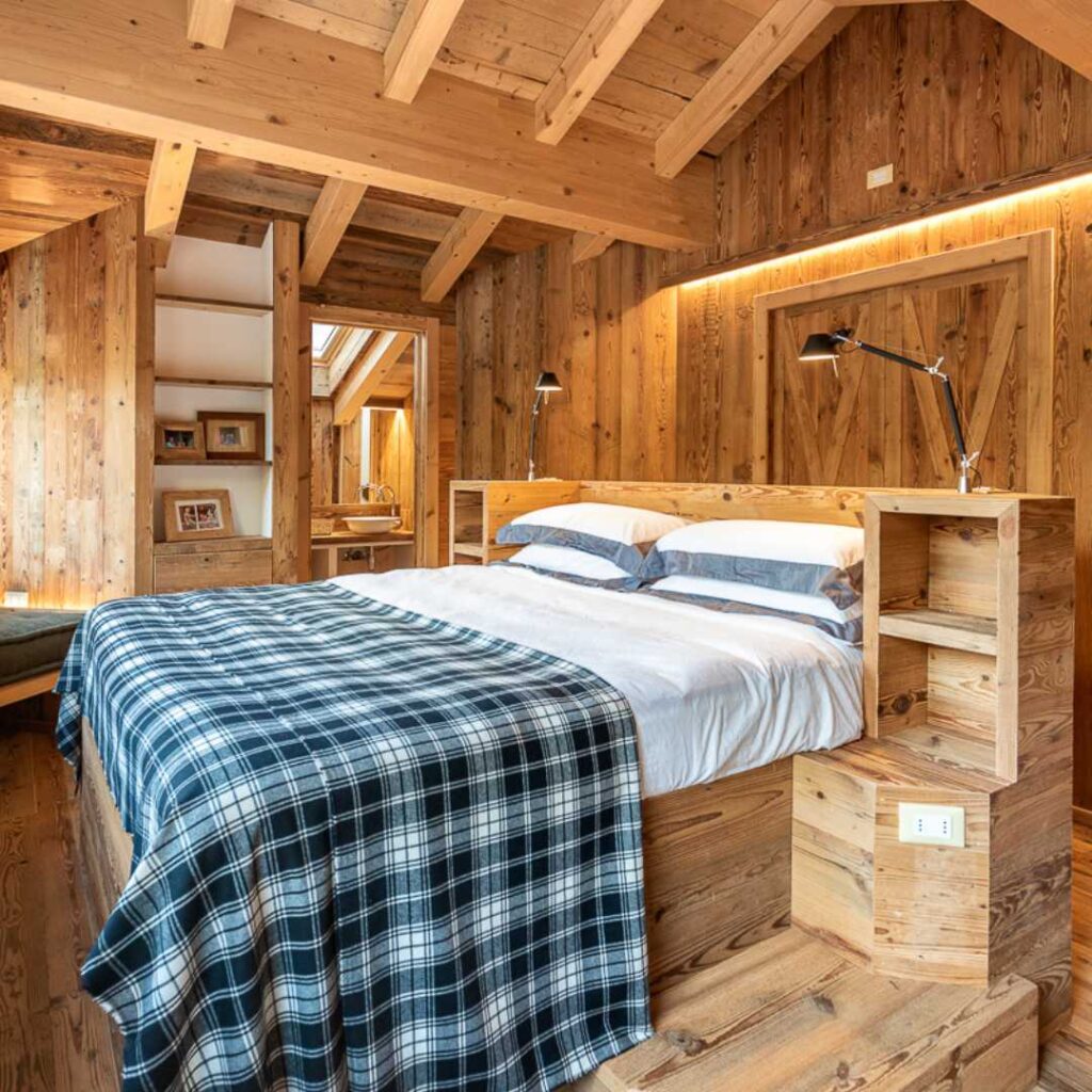 Camera da letto matrimoniale tutta in legno di una baita di montagna