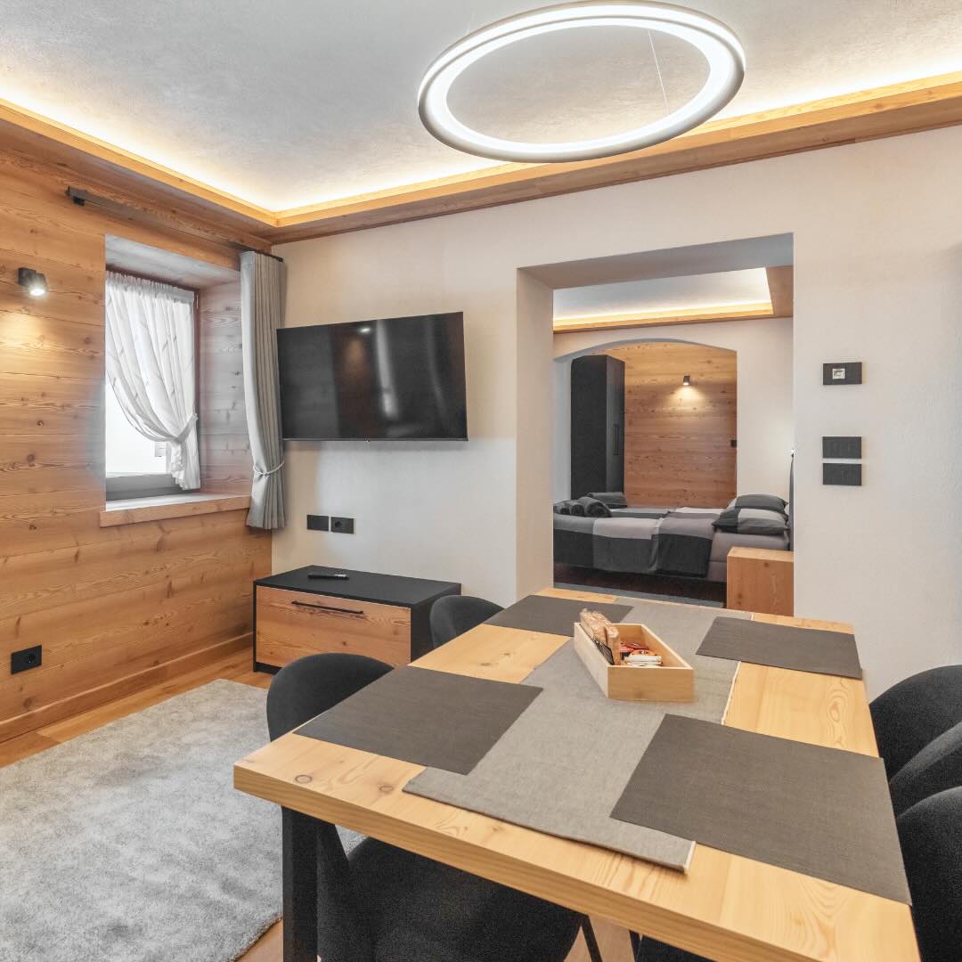 Tavolo in legno moderno con gambe di ferro e parete in legno