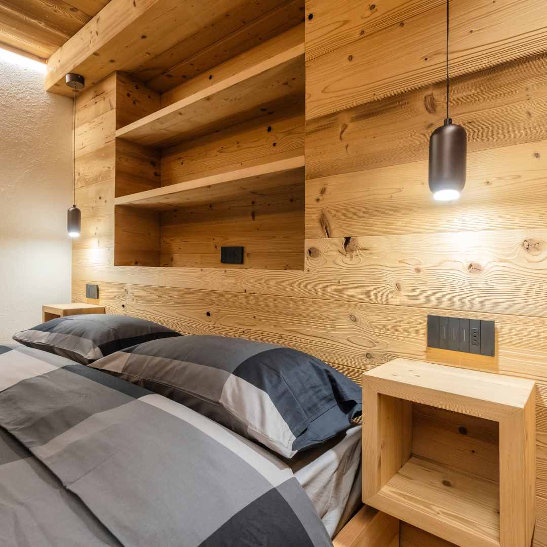 Camera da letto con parete in legno di abete con mensole integrate