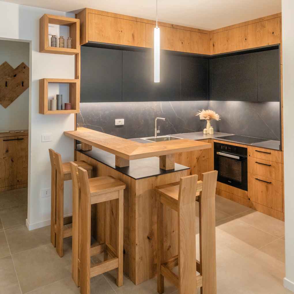 Cucina con doppi pensili in rovere e nobilitato e piano snack con sgabelli