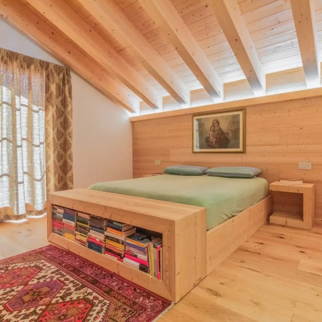 Camera matrimoniale in legno chiaro su misura con scaffalatura sul letto
