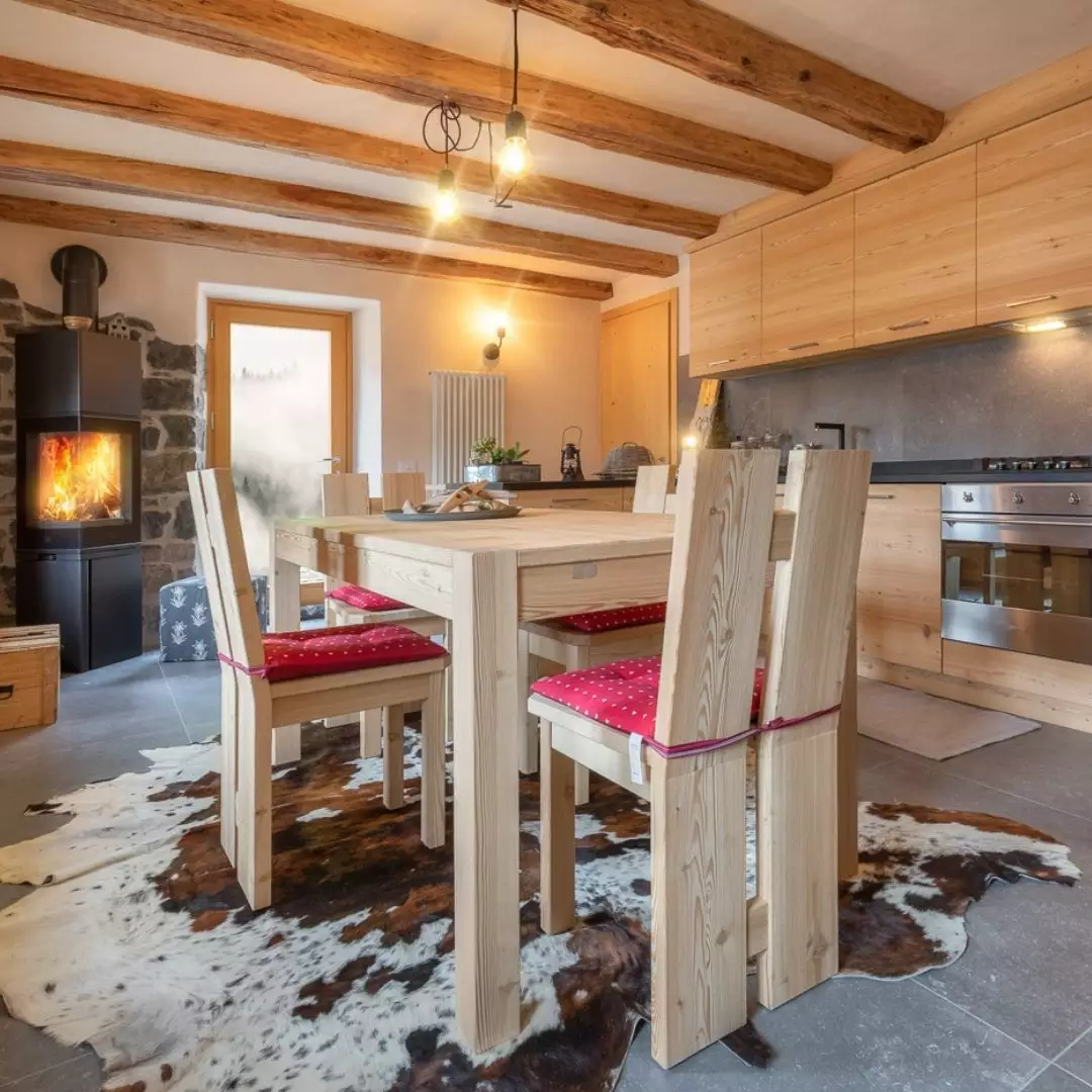 Cucina di montagna con sedie moderne in legno