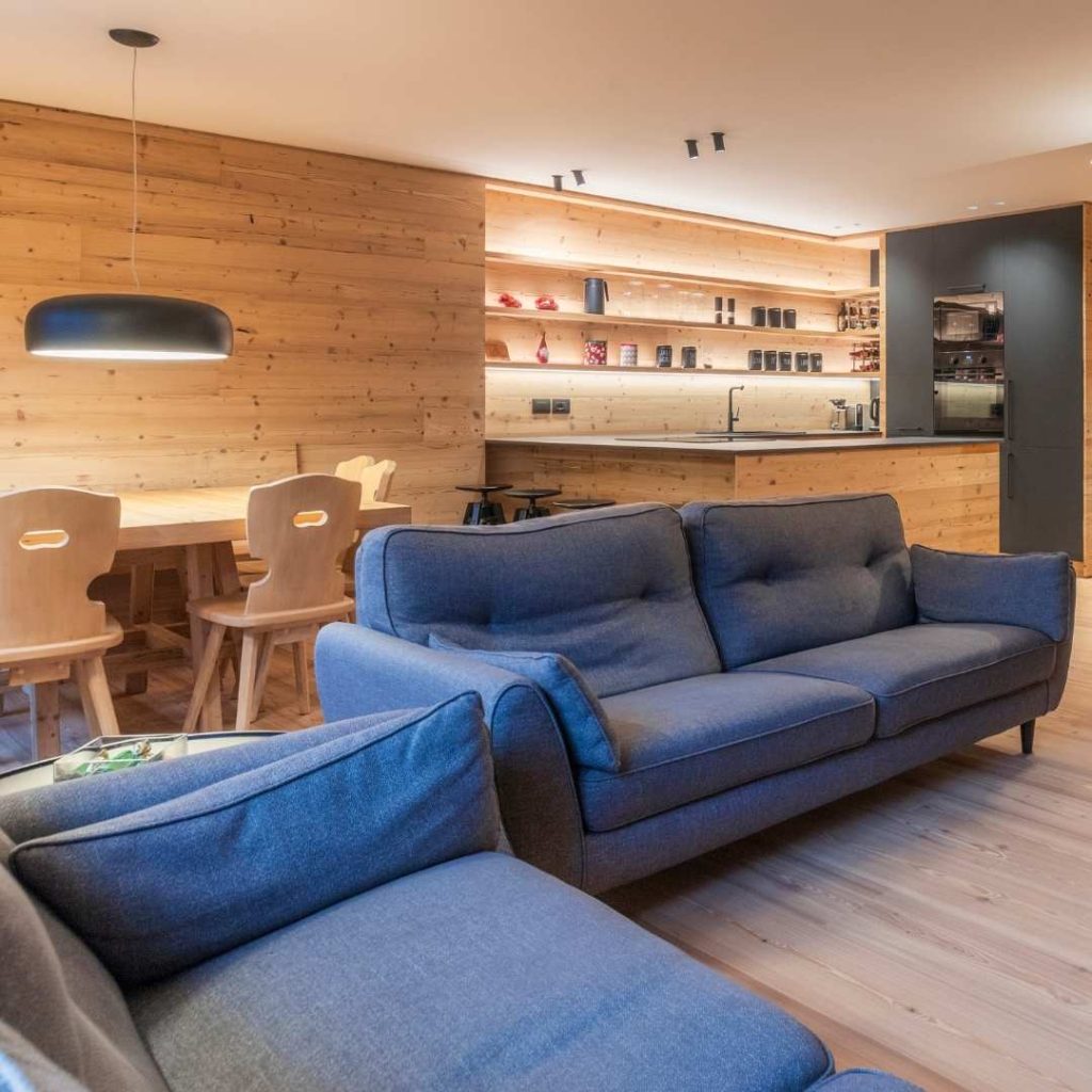 Cucina open space con mensole retroilluminate e calata sopra il tavolo